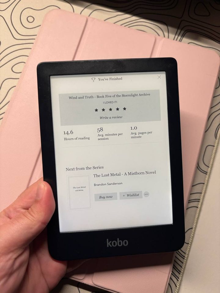 A Kobo e-reader showing a finished five-star read of Brandon Sanderson's Wind and Truth, with The Lost Metal queued up next.